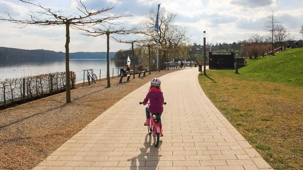 Ein Kind auf dem Fahrrad am Sorpesee im Frühling Ausflugsziel im Sauerland